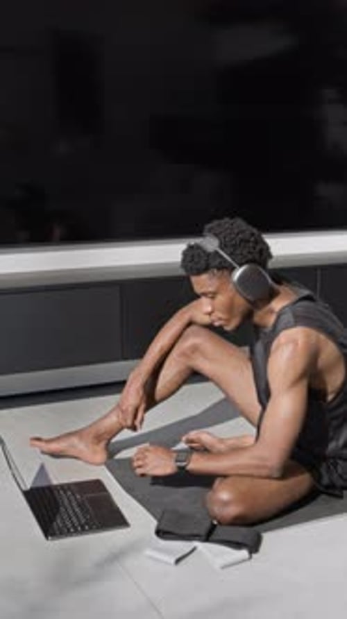 Athletic man sits and uses laptop