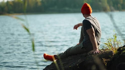 Unity Of Man And Nature Lonely Male Tourist Sitting On Coast And Admiring Beauty Of Lake Or River