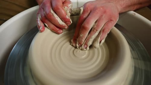 Crop of Unknown Man Artisan in Pottery Workshop Making Clay Pot on Rotary Machine