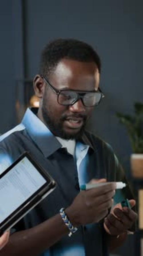 Manager Discussing Working Tasks with Colleague Using Tablet at Office