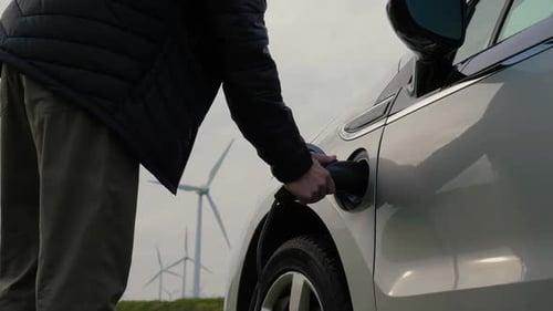 Man Unplugs Electric Car by Wind Farm