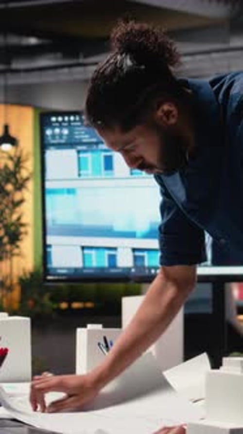 Vertical Video Middle Eastern Real Estate Developer Evaluates Construction Site Blueprints