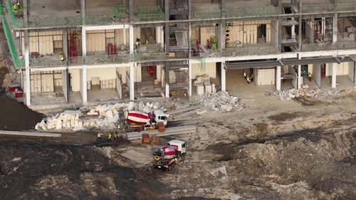 Hochwinkelaufnahme, die Bauarbeiter und Schwerarbeiter bei einem großen Bauprojekt zeigt,