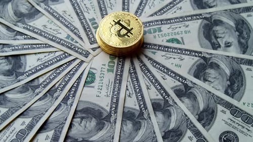 Bitcoin-Münze dreht sich über US-Dollar-Scheinen — Finanz- und Kryptowährungskonzept