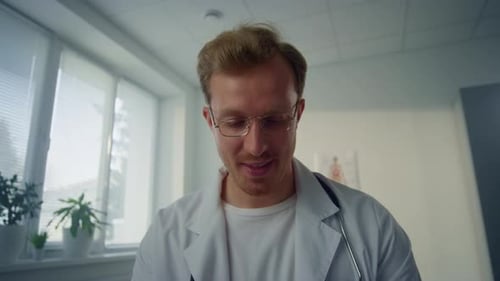 Smiling Young Doctor Giving Medical Consultation in Health Clinic Pov Video. Portrait