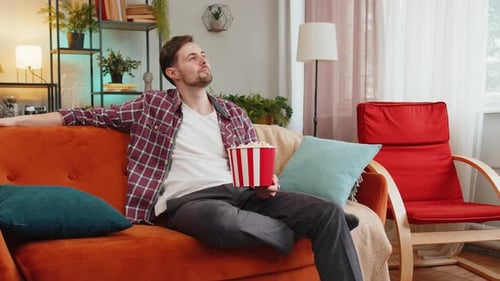 Young Man Relaxing on Sofa Watching a Movie