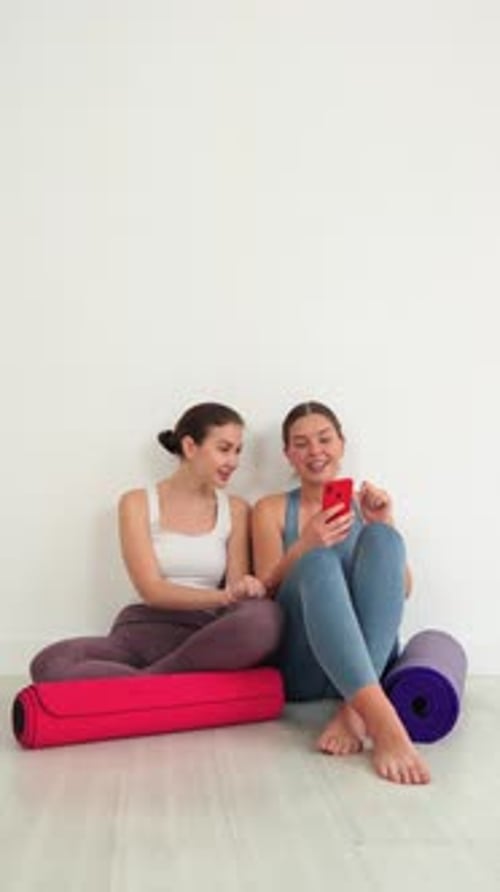 Women Friends Using Smartphone After Yoga Workout