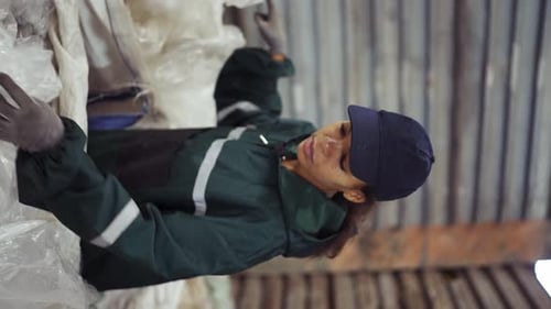 An AfricanAmerican Woman in a Special Uniform Sorts Polyethylene at a Waste Recycling Plant