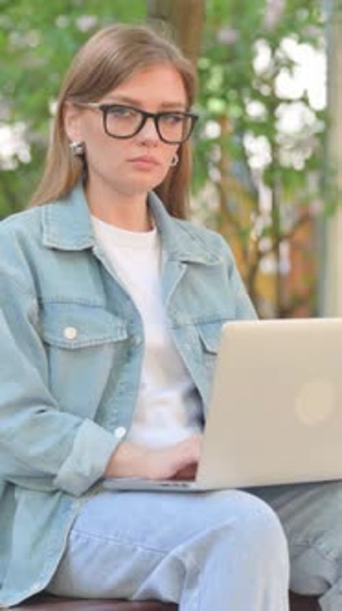 Vertical Video, Young Woman Smiling with Laptop in Park