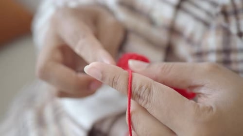 Close Up of Hands Crocheting with Red Yarn