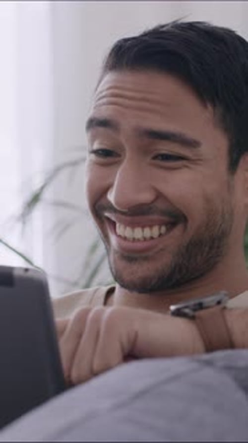 Tablet, smile and relax with man on sofa in home for social media post, streaming service