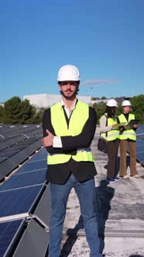 Selbstbewusster Solarenergieingenieur posiert in einer Photovoltaikanlage