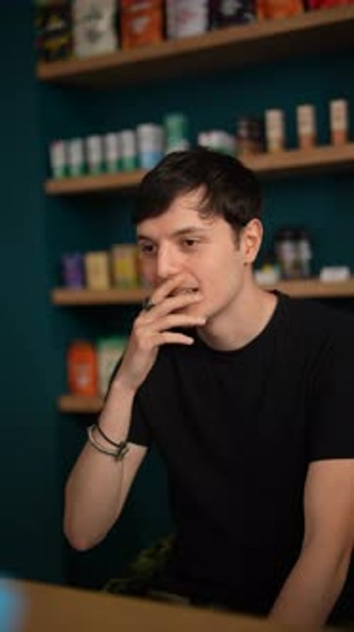 Man Talking and Gesturing in a Modern Cafe Environment Engaged in a Conversational Interaction
