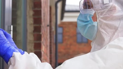 Worker Puts Biohazard Sign on Doorway Entrance