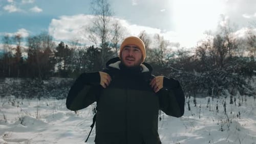 Man Hiking Through Snowy Winter Forest Landscape