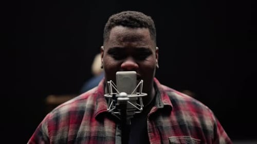 Man Singing into Microphone in Recording Studio