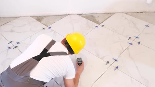 A Professional Builder Installs Ceramic Tiles in a New Building