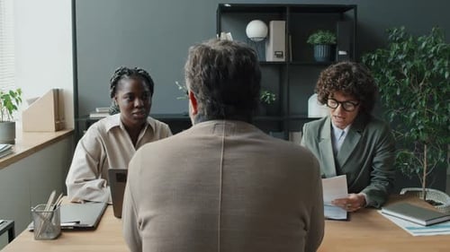 Caucasian Man Having Job Interview With Black And Caucasian Female HRs In Office