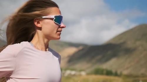 Professional Athlete Runs on a Mountain Road Boosting Endurance with Wind