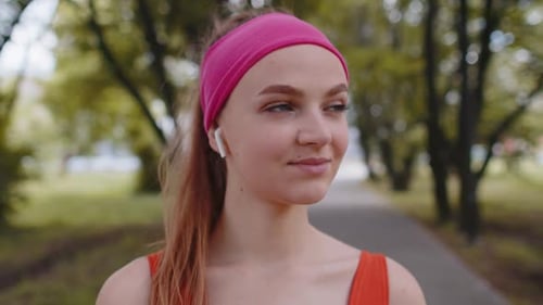 Portrait of Athletic Sport Runner Girl Training Listening Favorite Music Song in Earphones in Park