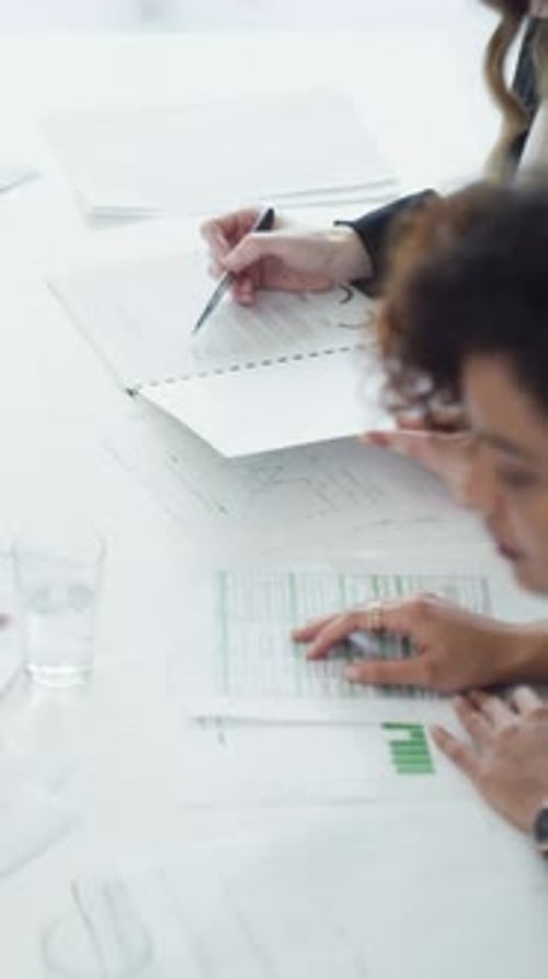 Professionals Reviewing Reports Together at Bright White Table