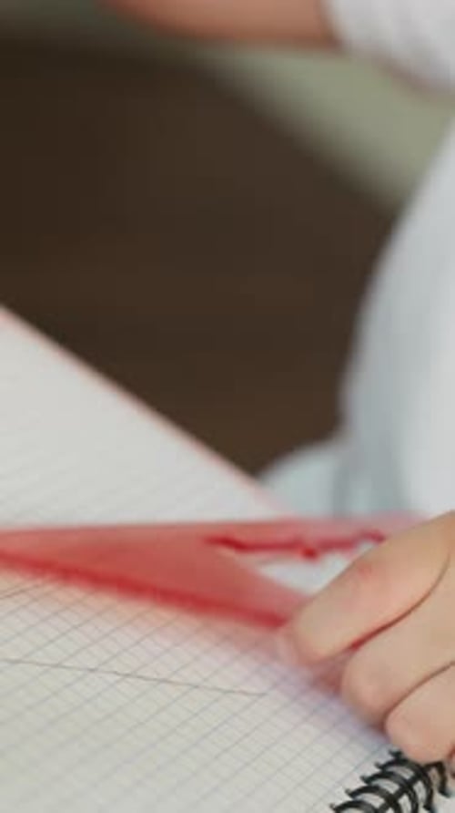 Child Draws Lines with Pencil and Triangular Ruler