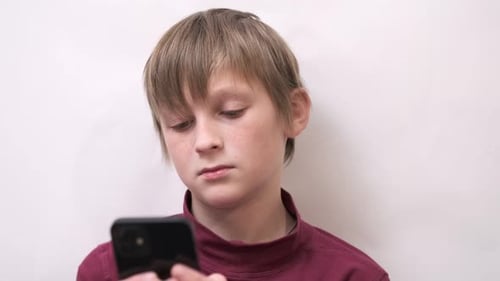 Teenage Boy Using Smartphone Indoors Close Up