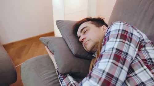 An Elderly Sick Man in a Scarf and a Plaid Shirt Tired Falls on the Pillows to Rest and Overcome the
