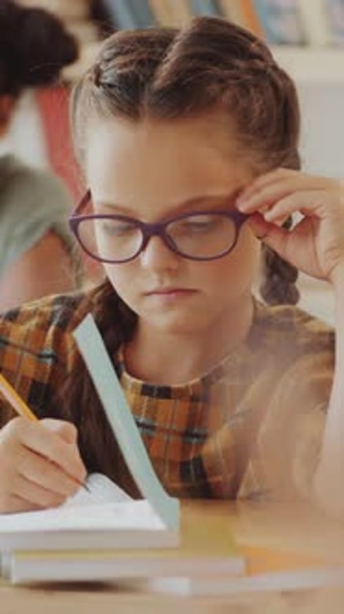 Focused Girl Doing Homework in a Classroom