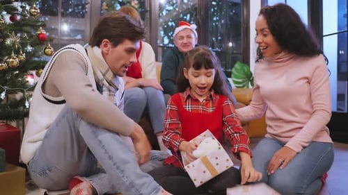 Caucasian family exchanging presents during Christmas party at home.