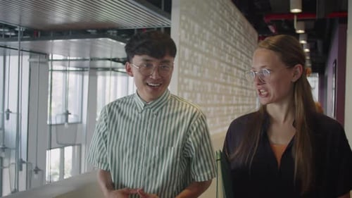 Young Multi-Ethnic Colleagues Walking in Office and Talking