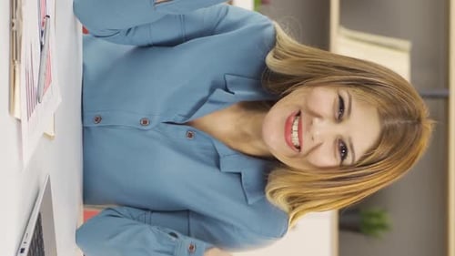 Smiling Woman at Her Desk in Office Setting