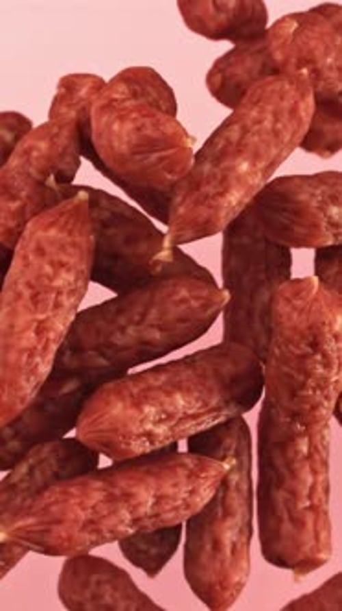 Mini Sausages Flying on a Pink Background Filmed on a Highspeed Camera at 1000 Fps