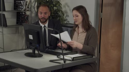 Colleagues Working Together at Desk in Office