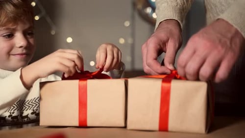 Boy and Man Wrapping Holiday Presents Together
