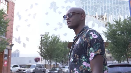 Stylish young man stands confidently on a New York City street in slow motion