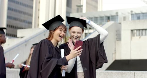 Diversas mulheres graduadas estendendo o telefone, iniciando a chamada para a formatura, acenando diplomas na praça