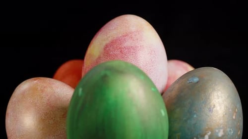 Eine Gruppe bunter Ostereier, darunter grüne, orange und rosa-gelbe Marmoreier, die zusammen angeordnet sind