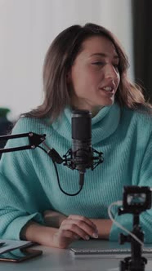 Woman Talking Into Microphone at Desk