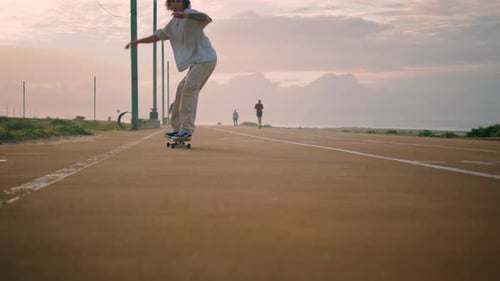 Young Skater Performing Trick on Sunset Street Skateboarder Jumping Longboard