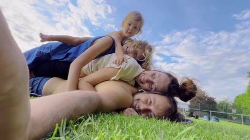 Happy Family Including Mother Father and Two Kids are Enjoying the Summer Holidays in the Garden or