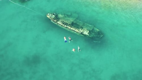 Tourists Swim At Blue Sea Over Shipwreck, Ribolovac In Solta Island, Croatia. - aerial