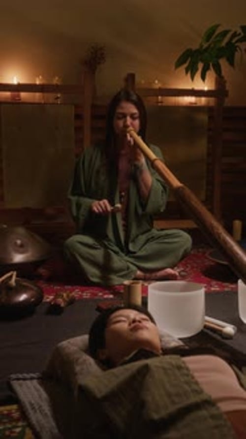 Female Performer Playing Didgeridoo during Sound Healing Meditation