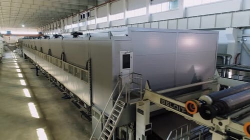 Brown Paper Rolls in Production Line and Worker at Plant
