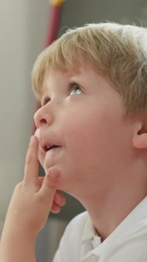 Little Boy Gazing Upward Indoors During Daytime