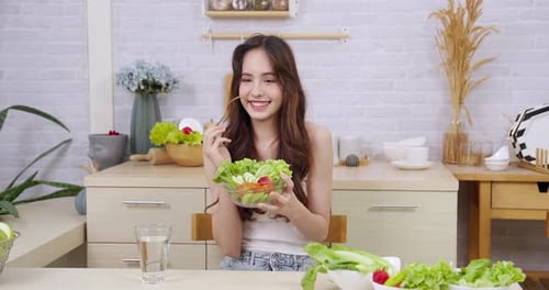 Woman Enjoying Healthy Salad in Bright Kitchen