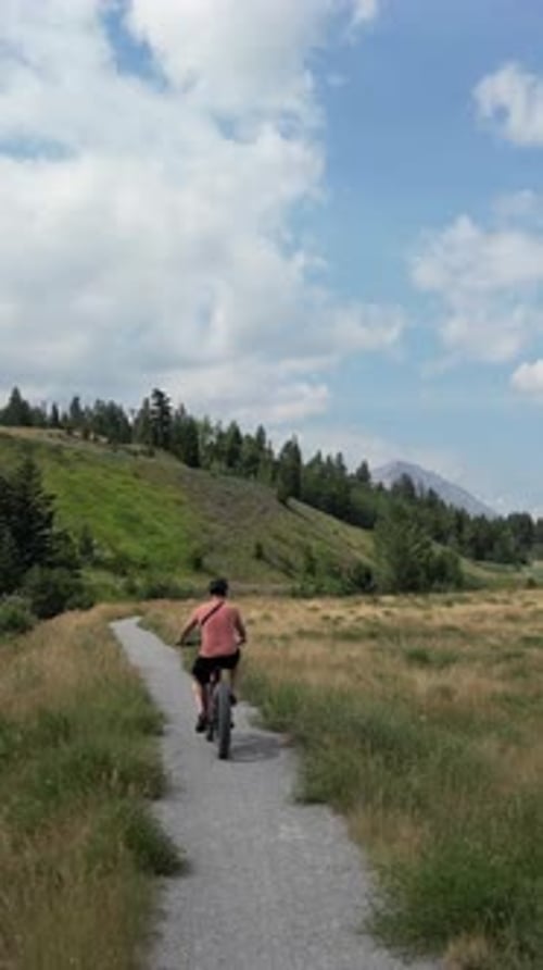 Man Enjoys Scenic Electric Bike Ride On Path. Crowsnest Pass, Alberta, Canada.