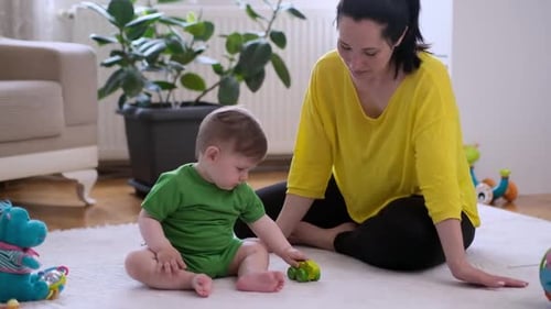 Mother and Baby Playing Together on Rug Indoors