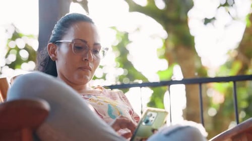 Woman Relaxing and Using a Mobile Phone Outdoors