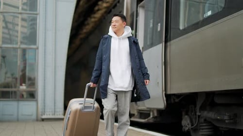 Man asian passenger arrives or departure by train home in town, with big suitcase, tourist